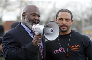 Mayor Mike Bell speaks with Toledo Public Schools' soon-to-be superintendent Romules Durant during a rally against violence.
