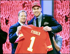 Central Michigan offensive tackle Eric Fisher holds his jersey along with NFL commissioner Roger Goodell after being selected first overall by the Kansas City Chiefs in NFL draft.