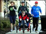  Erin O'Connell, left, Toledo Roadrunners volunteer coordinator, Jessy Meeker, and Mark Armstrong push Robin Hanna Mower on the first leg of the 3-mile run during the weekly Second Sole of Toledo run at Levis Commons in Perrysburg. Mrs. Mower will participate in Sunday’s race.