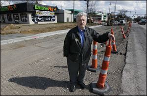 Mike Saine, manager of Batteries Plus store, stands amidst the Secor Road construction in front of his shop on April 24, 2013.