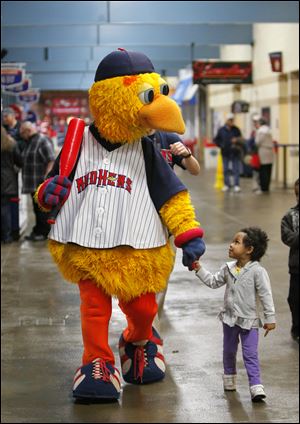 Muddy the Mud Hen walks with Myschell Gaitor, 3, along the concourse at Fifth Third Field.