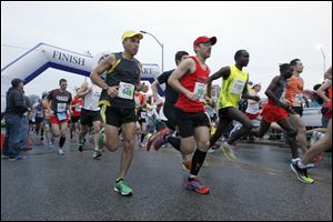 Runners take off at the start of  the 2013 Medical Mutual Glass City Marathon at the University of Toledo on Sunday.