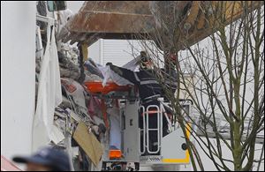 French firemen carry the body of an unidentified victim from a building hit by an explosion that caused the collapse of its inside floors, in Reims, eastern France early today.