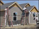  Jeffrey Hughes Construction workers Cory Notman, left, and Joe Metzler install siding on the Kensington Gardens Apartments at 8375 Waterville-Monclova Rd. in Waterville. 