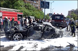 Syrian fire fighters extinguish burning cars after a car bomb exploded in the capital's western neighborhood of Mazzeh, in Damascus, Syria, today.