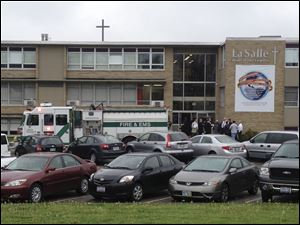 Police and firefighters gather outside LaSalle High School, Monday, in Cincinnati, after a student pulled out a gun and shot himself in a classroom. The youth was taken to a hospital with a self-inflicted wound.