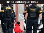  Cincinnati police detain a suspect after targeting members of the Walnut Hills Posse in 2011. Gang-related homicides dropped 42 percent after the effort.