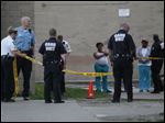  Authorities investigate the scene of a shooting today at Greenbelt Place apartments.