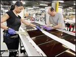  Jasmine James, left, and Jonathan Smith assemble solar panels at Xunlight Corp.  The company has expanded past the 100-employee mark and is focusing on doubling its growth.