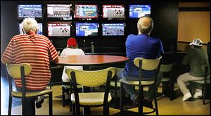 Horse racing fans watch both harness and thoroughbred races on simulcast at Raceway Park on Wednesday. Live racing is held on Saturdays and Sundays.