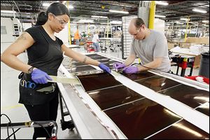 Jasmine James, left, and Jonathan Smith assemble solar panels at Xunlight Corp.  The company has expanded past the 100-employee mark and is focusing on doubling its growth.