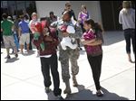  Sgt. Renata Morgan, of North Toledo, center, talks with her son Kelvin Gist, Jr., 11, left, and niece Ja'Lycia Price, 9, right, Thursday afternoon at the conclusion of the welcome home ceremony held for the 323rd Military Police Company at Cedar Creek Church in Perrysburg.