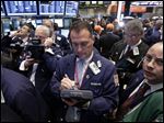  Traders gather at a post on the floor of the New York Stock Exchange.