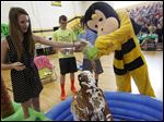  Ally Stegman, 13, left, joins other students and the Perrysburg mascot in covering algebra teacher Glenn McIntyrt, center, in toppings during a pep assembly at Perrysburg Junior High.