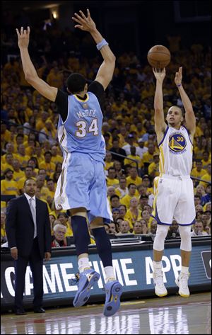 Golden State Warriors' Stephen Curry (30) shoots over Denver Nuggets' JaVale McGee (34) during the first half of Game 6.