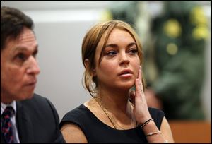 Actress Lindsay Lohan appears in Los Angeles court with her new attorney Mark Heller, left, for a pretrial hearing, Wednesday, Jan. 30, 2013, in a case filed over the actress' June car crash.