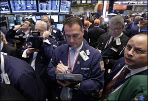 Traders gather at a post on the floor of the New York Stock Exchange.