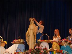 Brittanie Kuhr crowns a statue of Mary in 2009.