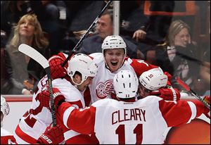 Red Wings center Gustav Nyquist, top, celebrates his winning goal with Jonathan Ericsson, left, Daniel Cleary, and Valtteri Filppula against the Anaheim Ducks during overtime in Game 2 on Thursday night. The series is now tied at a game apiece.