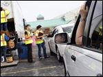  Barry Deutsch, of Perrysburg, right, waits in his car for his turn to deposit his recycling.