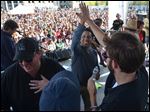  Actor Oscar Nunez, center, high-fives cast mate John Krasinski after singing on stage during 