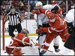  Wings defenseman Niklas Kronwall clears the puck from Anaheim's Corey Perry in front of Red Wings goalie Jimmy Howard during the first period.