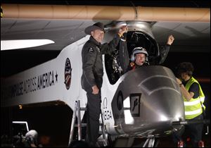 Solar Impulse co-founder, pilot and CEO Andre Borschberg, left, greets pilot Bertrand Piccard at Sky Harbor International Airport in Phoenix after completing the first leg of its coast-to-coast flights across the United States.