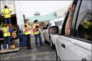 Barry Deutsch, of Perrysburg, right, waits in his car for his turn to deposit his recycling.