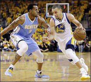 Golden State's Stephen Curry drives the ball against Denver's  Andre Iguodala. 