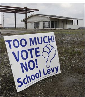 A sign against the BG school levy is placed in front of an abandoned gas station on Wooster St. just east of I-75 in Bowling Green, Ohio.