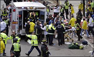 Medical workers aid injured people after two bombs exploded near the finish line of the Boston Marathon in Boston, April 15.