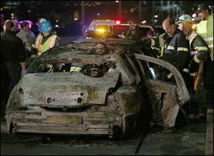 San Mateo County firefighters and California Highway Patrol personnel investigate the scene of a limousine fire on the westbound side of the San Mateo-Hayward Bridge in Foster City, Calif., Saturday.