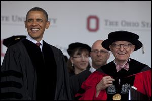 President Obama and Ohio State University President E. Gordon Gee arrive at the Ohio State University spring commencement in the Ohio Stadium.