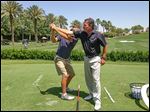  Mike Mitchell helps a golfer at a club in California where he is the course pro. A former Maumee resident, he has qualified for the Senior PGA Championship.