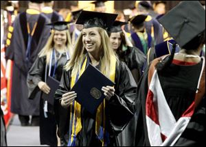 Sarah Hess, center, celebrates receiving her diploma during Sunday’s commencement ceremony at the University of Toledo. With the end of the academic year, 3,041 students were eligible for degrees.