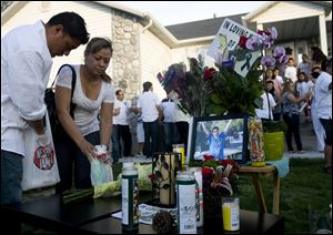 Alex Flores, left, and Silvia Castro place candles at a vigil for Ricardo Portillo, who passed away after injuries he sustained after an assault by a soccer player at a game he was refereeing on April 27.