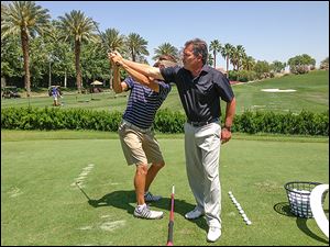 Mike Mitchell helps a golfer at a club in California where he is the course pro. A former Maumee resident, he has qualified for the Senior PGA Championship.