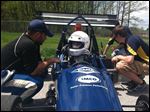  From the University of Toledo engineering team, A.J. Lesiecki talks strategy with driver Will Benson as part of a Formula race car event at Owens Community College.