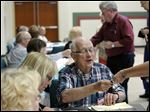  Election judge Bob Bachman checks in a voter at busy Bowling Green Church of the Nazarene.