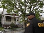  A sheriff deputy stands outside a house where three women escaped Tuesday, May 7, 2013, in Cleveland. Three women who went missing separately about a decade ago were found in the home Monday just south of downtown and likely had been tied up during years of captivity, said police, who arrested three brothers. (AP Photo/Tony Dejak)