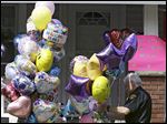  A Cleveland policeman carries balloons and flowers to the front porch of a home awaiting the arrival of Amanda Berry on Wednesday. 
