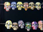  ADVANCE FOR USE SUNDAY, OCT. 30, 2011 AND THEREAFTER - FILE - In this Nov. 1, 2006 file photo, a man stands in front of an art piece of painted skulls in Mexico City's Zocalo plaza during Day of the Dead festivities. Day of the Dead, a colorfully macabre celebration harkening back to the Aztecs is observed on the Catholic All Saints' Day. 
