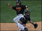  Rochester's Doug Bernier gets by Toledo catcher Ramon Cabrera to score on a double by former Mud Hen Clete Thomas.