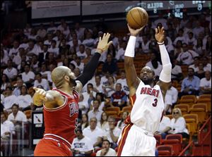 Miami Heat guard Dwyane Wade shoots against Chicago Bulls forward Carlos Boozer.