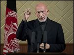  Afghan President Hamid Karzai gestures during a ceremony at Kabul University in Kabul, Afghanistan, today. Karzai said he is ready to let the U.S. have nine bases in the country after the 2014 combat troop pullout, but wants Washington’s “security and economic guarantees” first.
