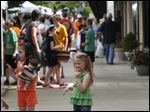  Sisters McKenna, 7, left, and Maleah Cope, 5, center, snack on popsicles as their mother Susan, of Perrysburg, makes a purchase from a local vendor during the first day of the downtown Perrysburg Farmer's Market.