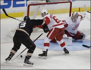 Anaheim Ducks center Nick Bonino, left, scores the winning goal past Detroit Red Wings' Joakim Andersson goalie Jimmy Howard and during overtime Wednesday in Anaheim, Calif.