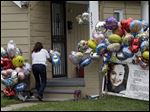  Culema Nevarez adds balloons to a growing tribute outside the home of Gina DeJesus in Cleveland.