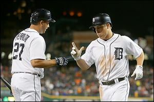 The Tigers' Andy Dirks, right, celebrates with teammate Jhonny Peralta after hitting a solo home run during the seventh inning.