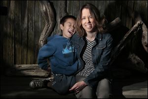 Tara Sievers and her son, Bodhi, 7, pose for portrait at their Belmont Shores home. The City of Long Beach is cutting hours for some part-timers to avoid benefit costs under the federal healthcare law. Longtime parks employee Sievers is affected by this and has complained to city officials about them hurting workers and dodging the new law.